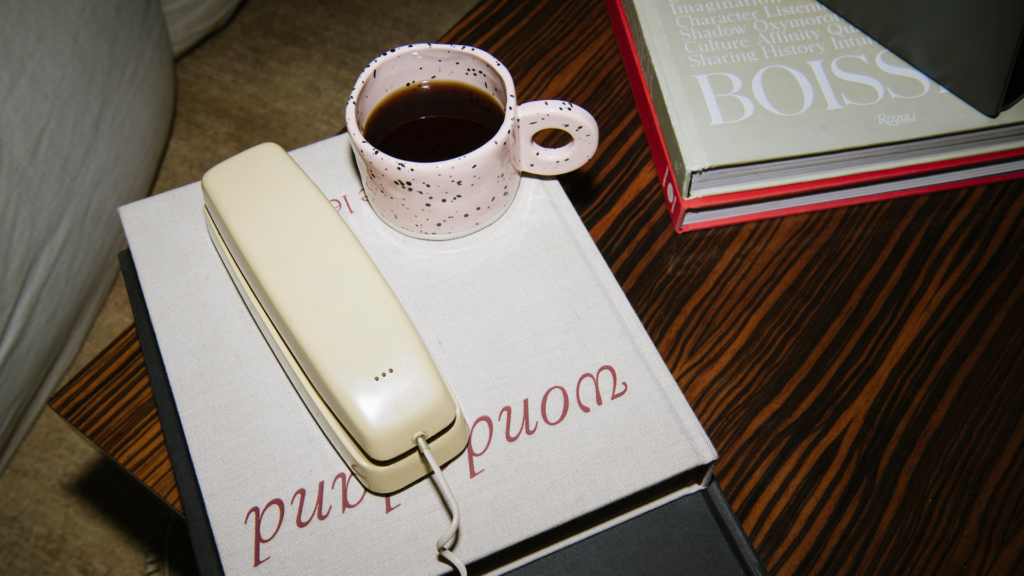 Bad debt deductions concept shown with a vintage office phone, coffee cup, and books on a wooden table