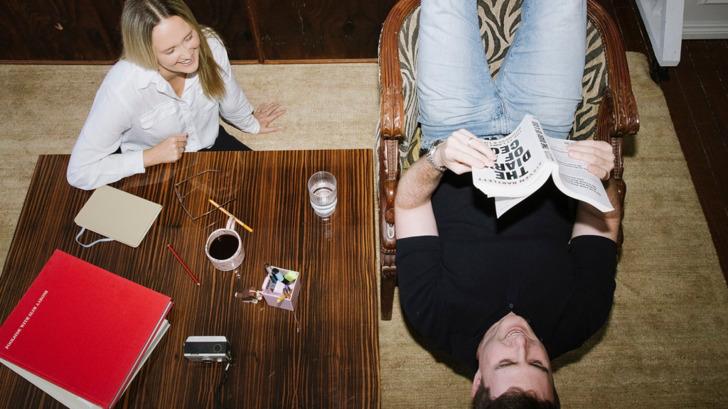 Overhead view of two colleagues reviewing paperwork at a desk, representing business expense claims and accounting support in Australia.