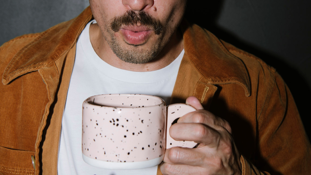 Trades business owner holding a coffee cup while reviewing accounting needs for tax, BAS and cashflow