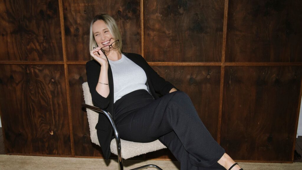 Business professional holding glasses in an office setting for an article about negative gearing changes.